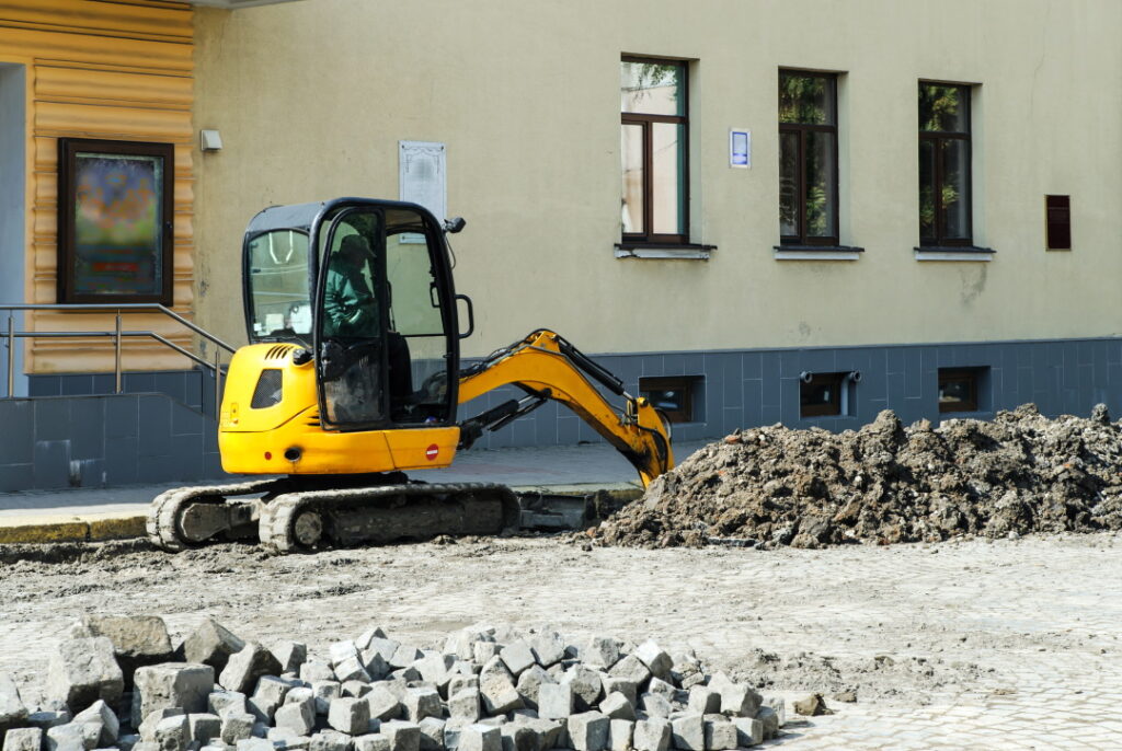 Tractor digger is digging a trench for the installation of water pipes.